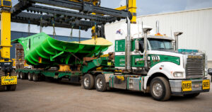 Performance Mining's distinctive green Hercules truck bed being loaded by CombiLift onto truck leaving Schlam's Forrestfield facility